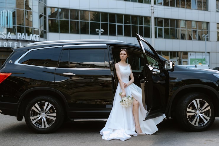 Bride beside luxury chauffeur vehicle before wedding ceremony